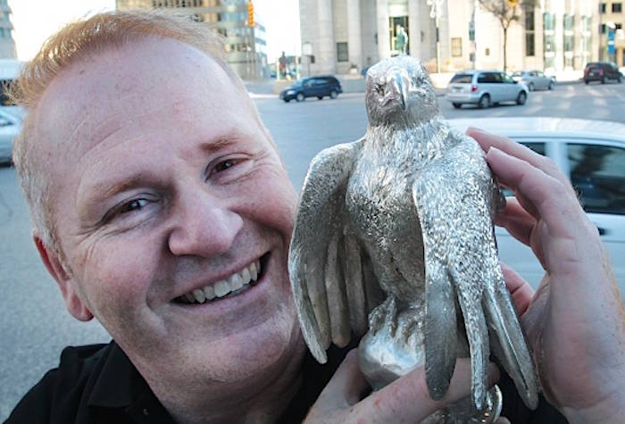 Ron Shore holds a solid silver eagle statue at Portage and Main St in Winnipeg Nov. 3, 2010. (THE CANADIAN PRESS/ Winnipeg Free Press - Joe Bryksa)