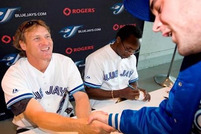 Former Toronto Blue Jays greats Kelly Gruber, left, and Tony Fernandez sign autographs and meet fans on Friday, June 5, 2009 during 20th Anniversary celebrations of the Blue Jays playing at the Rogers Centre in Toronto. The Canadian Baseball Hall of Fame removed former Blue Jays third baseman Kelly Gruber from its induction week festivities Friday after his actions during a “Pitch Talks” panel discussion a day earlier. THE CANADIAN PRESS/Darren Calabrese