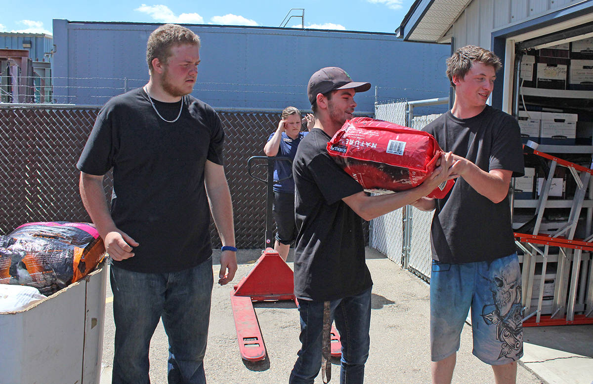 FILL IT UP - Volunteers with the Red Deer Food Bank came out to Alberta Animal Services June 19th to fill up thousands of pounds of pet food for Red Deerians who are less fortunate. Carlie Connolly/Red Deer Express