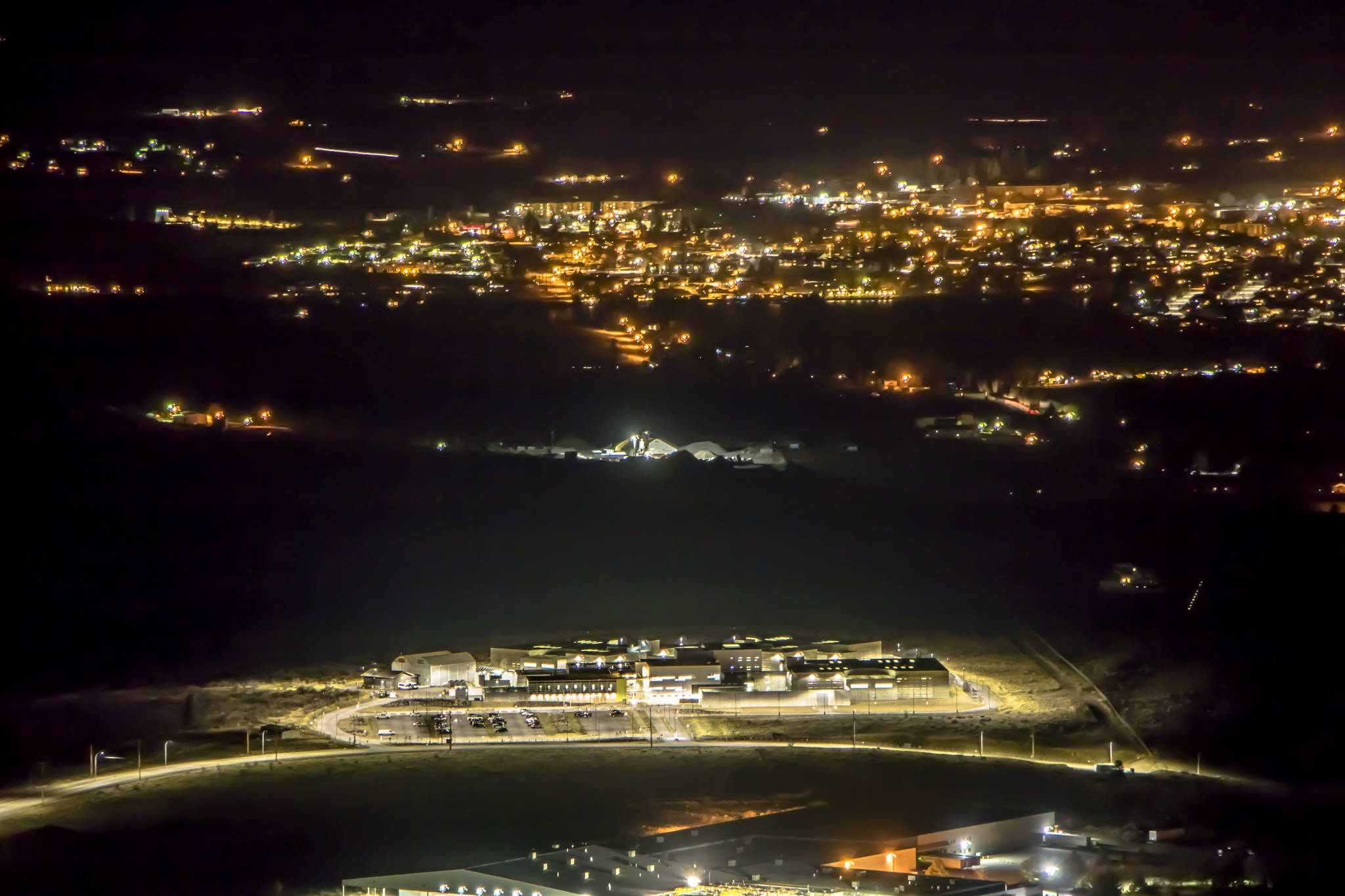 Seen from McIntyre Bluffs one February night, the Okanagan Correctional Centre is flooded with light, next to the darkness of empty land and the starlike twinkle of Oliver’s streetlights.                                Dustin Godfrey/Western News