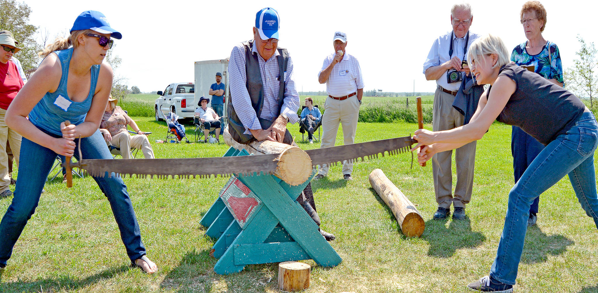 Liisa Tipman, right, and Aili Kuutan participate in the pioneer game of log sawing during the Estonia Celebration in Stettler County June 23. Liisa lives in Calgary and her family still resides in Big Valley. Aili lives in Toronto and her family still resides in Big Valley. Liisa and Aili are cousins and descendants of the Tipman pioneer family. (Lisa Joy/Black Press News Services)