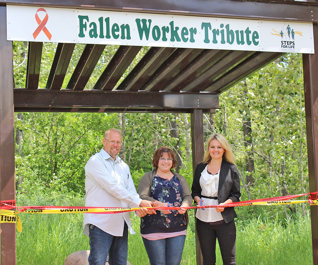PAYING TRIBUTE - Brad Vonkeman, Rebecca Orr and Tara Veer take part in the official ribbon cutting at the grand opening of the Fallen Worker Tribute at Bower Bonds June 25th. Carlie Connolly/Red Deer Express