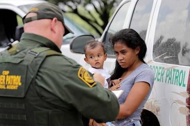 A mother migrating from Honduras holds her 1-year-old child as surrendering to U.S. Border Patrol agents after illegally crossing the border Monday, June 25, 2018, near McAllen, Texas. (AP Photo/David J. Phillip)