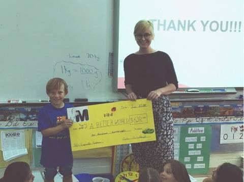 RAISING FUNDS - Mattie McCullough Elementary School student Justin Gilbertson presenting the proceeds of the Grade 3 fundraiser to A Better World Communications Specialist Jacqui McCarty on June 20th. Photo submitted