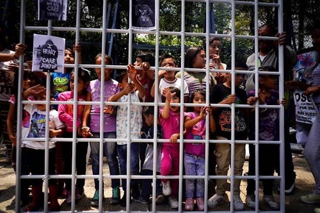 Children hold up a metal fence to symbolize immigrant children detained by U.S. immigration authorities and separated from their families, as they pose for photographers outside the U.S. embassy in Mexico City, Tuesday, June 26, 2018. The protest was organized by Lorena Osorio, independent candidate for Mexico City mayor ahead of July 1 elections. (AP Photo/Ramon Espinosa)