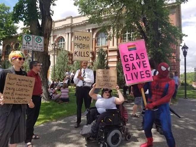 People hold signs outside of a courthouse in Medicine Hat, Alta. on Wednesday, June 20, 2018. THE CANADIAN PRESS/Lauren Krugel