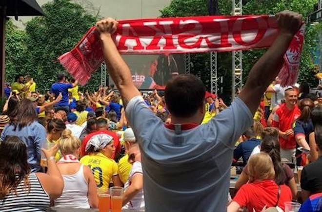 A fan of Poland holds up a scarf as he watches a World Cup soccer match between Poland and Colombia at The Garden at Studio Square NYC in New York on Sunday, June 24, 2018. (AP Photo/Terrin Waack)