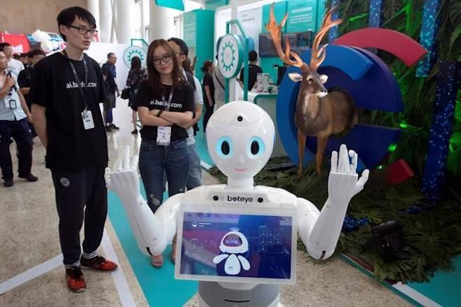 In this July 4, 2018, photo, a robot from Chinese search company Baidu welcomes visitors to a developer event in Beijing, China. (AP Photo/Ng Han Guan)