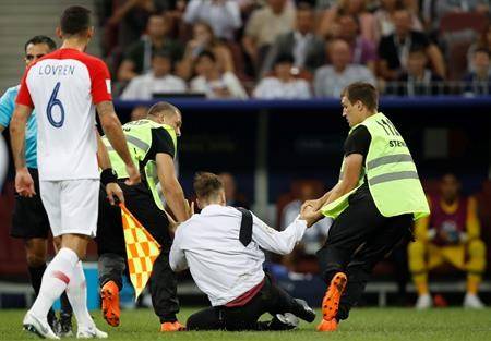 Security stewards remove people who ran onto the pitch and briefly stopped the final match between France and Croatia at the 2018 soccer World Cup in the Luzhniki Stadium in Moscow, Russia, Sunday, July 15, 2018. (AP Photo/Francisco Seco)