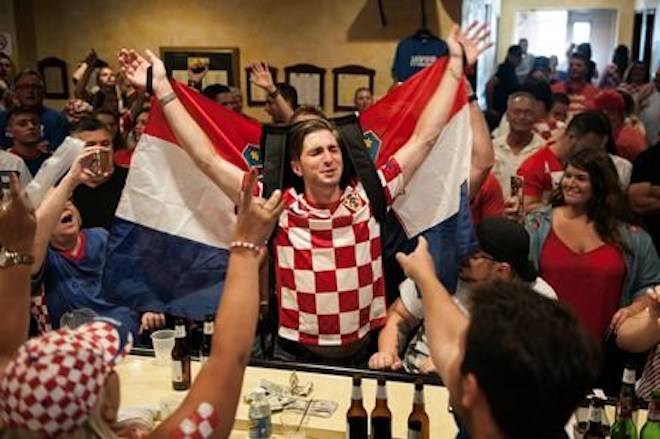Marko Luketich Kochis, center, raises the flag Croatia as he celebrates that his team is in the World Cup soccer final against France as people gather to watch the televised game Sunday, July 15, 2018, at Croatian National Hall Javor in Pittsburgh. (Stephanie Strasburg/Pittsburgh Post-Gazette via AP)