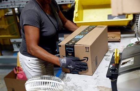 In this Aug. 3, 2017, file photo, Myrtice Harris applies tape to a package before shipment at an Amazon fulfillment center in Baltimore. (AP Photo/Patrick Semansky, File)