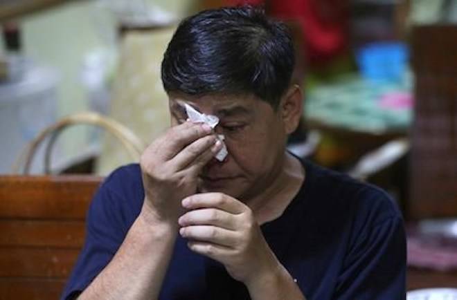 Banphot Konkum, the uncle of Duangpetch Promthep, one of the boys rescued from a flooded cave, wipes his eyes as he watches Duangpetch and the rest of the boys live on television recalling their ordeal in the cave at his home in Mae Sai district, Chiang Rai province, northern Thailand, Wednesday, July 18, 2018. (AP Photo/Sakchai Lalit)