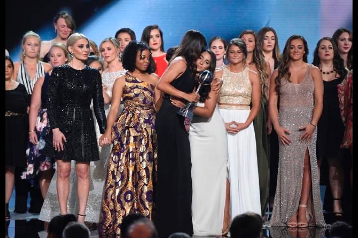 Jennifer Garner, front, embraces gymnast Aly Raisman after presenting the Arthur Ashe Award for Courage, at the ESPY Awards at Microsoft Theater on Wednesday, July 18, 2018, in Los Angeles. Holding hands in front left are former gymnast Sarah Klein and former Michigan State softball player Tiffany Thomas Lopez. More than 140 survivors of sexual abuse by a former team doctor for USA Gymnastics and Michigan State University joined hands on stage to be honored with the award. (Photo by Phil McCarten/Invision/AP)