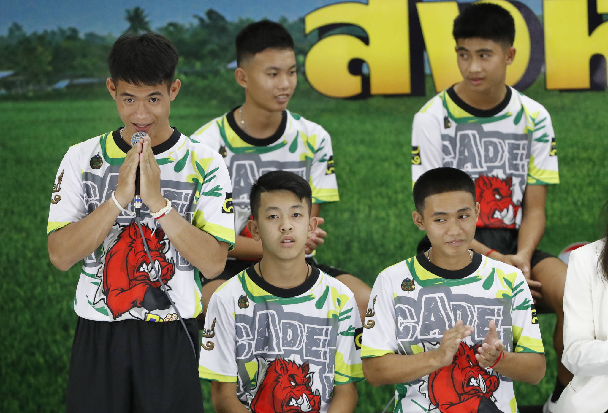 Coach Ekkapol Janthawong, left, and members of the rescued soccer team express their thanks during a press conference discussing their experience of being trapped in a flooded cave, in Chiang Rai, northern Thailand, Wednesday, July 18, 2018. The 12 boys and their soccer coach rescued after being trapped in a flooded cave in northern Thailand are recovering well and are eager to eat their favorite comfort foods after their expected discharge from a hospital soon. (AP Photo/Vincent Thian)