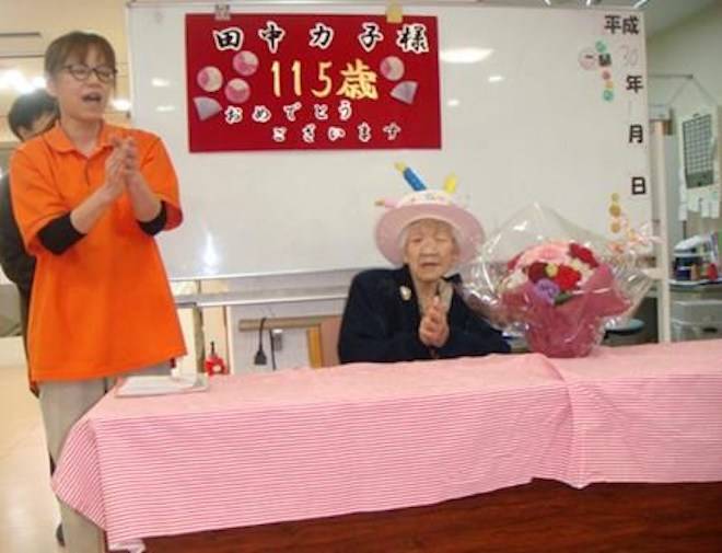 In this Jan. 2, 2018, photo provided by Goodtime Home 1, Kane Tanaka, right, is celebrated her 115th birthday at her nursing home in Fukuoka, southwestern Japan. (Goodtime Home 1 via AP)