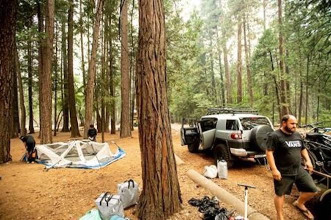 Miguel Martinez breaks camp at the Upper Pines Campground in Yosemite National Park, Calif., on Wednesday, July 25, 2018. Martinez and his family had to cut their stay short as portions of Yosemite close today to allow crews to battle the Ferguson fire burning nearby. (AP Photo/Noah Berger)