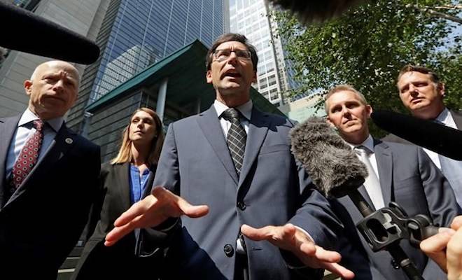 Washington Attorney General Bob Ferguson, center, speaks with media members following a hearing where a federal judge issued a temporary restraining order to stop the release of blueprints to make untraceable and undetectable 3D-printed plastic guns, Tuesday, July 31, 2018, in Seattle. (AP Photo/Elaine Thompson)