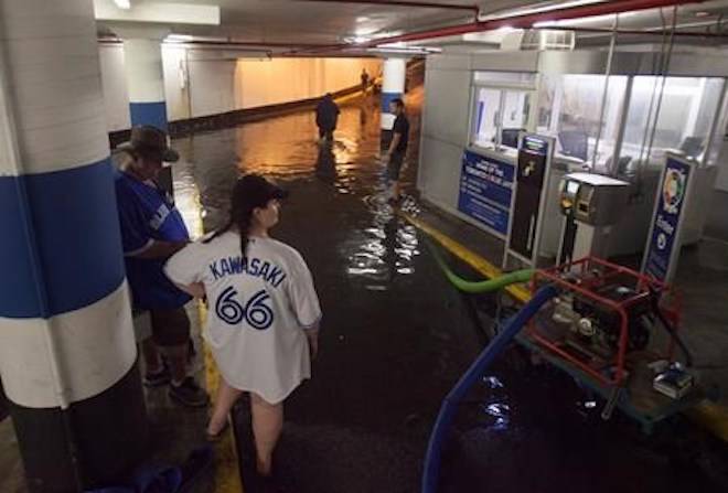 Toronto Blue Jays fans get stuck in the Rogers Centre as the entrance to the parking garage floods with torrential rain, in Toronto on Tuesday, August 7, 2018. THE CANADIAN PRESS/Fred Thornhill