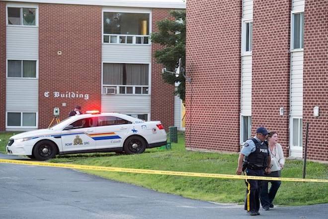 An RCMP officer and a resident carry a pet container from an evacuated apartment building in Fredericton on Friday, August 10, 2018. Two city police officers were among four people who died in a shooting in the residential area on the city’s north side. THE CANADIAN PRESS/Andrew Vaughan