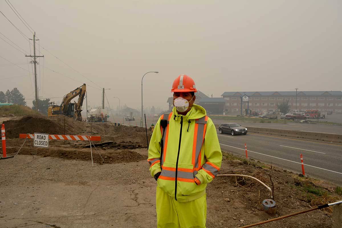 To handle the high risk air quality conditions in Williams Lake, Tyler Bobby, a flagger with Peterson Contracting, wears a mask Friday morning while working at the Highway 97 Toop and Carson intersection upgrade project.