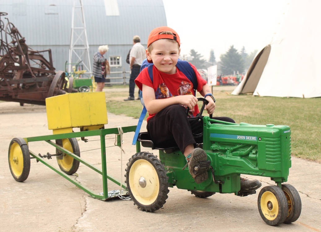 Karl Holba, five, concentrates on pulling his tractor Aug. 18th at Sunnybrook Farms’ Pioneer Days. Carlie Connolly/Red Deer Express