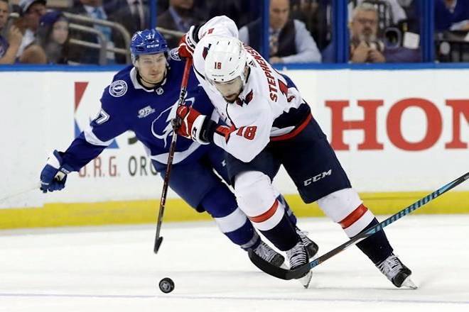 Washington Capitals center Chandler Stephenson (18) breaks out past Tampa Bay Lightning center Yanni Gourde (37) during the third period of Game 1 of the NHL Eastern Conference finals hockey playoff series Friday, May 11, 2018, in Tampa, Fla. STHE CANADIAN PRESS/AP-Chris O’Meara