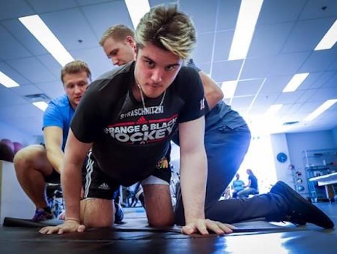 Humboldt Broncos bus crash survivor Ryan Straschnitzki attends a physiotherapy session with kinesiologist Kirill Dubrovskiy, left, and physiotherapist Nelson Morela, centre, in Calgary, Alta., Monday, Aug. 20, 2018.THE CANADIAN PRESS/Jeff McIntosh