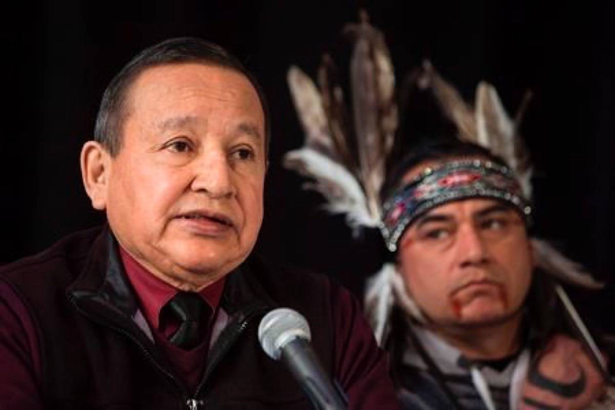 In this April 16, 2018 photo, the Grand Chief of the Union of British Columbia Indian Chiefs, Stewart Phillip, gives a news conference with indigenous leaders and politicians opposed to the expansion of the Trans Mountain oil pipeline in Vancouver, Canada. Behind is William George, a member of the Tsleil-Waututh First Nation and a guardian at the watch house near Kinder Morgan Inc. Burnaby oil facility. British Columbia’s union of Indigenous leaders says it remains opposed to the Trans Mountain pipeline expansion as Kinder Morgan Canada shareholders vote Thursday on the federal government’s purchase offer. (Darryl Dyck/The Canadian Press)