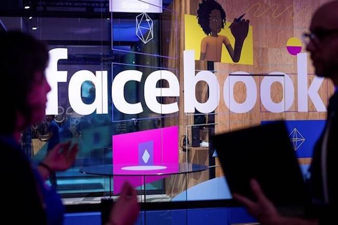 In this April 18, 2017, file photo, conference workers speak in front of a demo booth at Facebook’s annual F8 developer conference, in San Jose, Calif. Facebook and Instagram say it will charge goods and services taxes on online advertisements purchased through its Canadian operations. THE CANADIAN PRESS/AP/Noah Berger, File