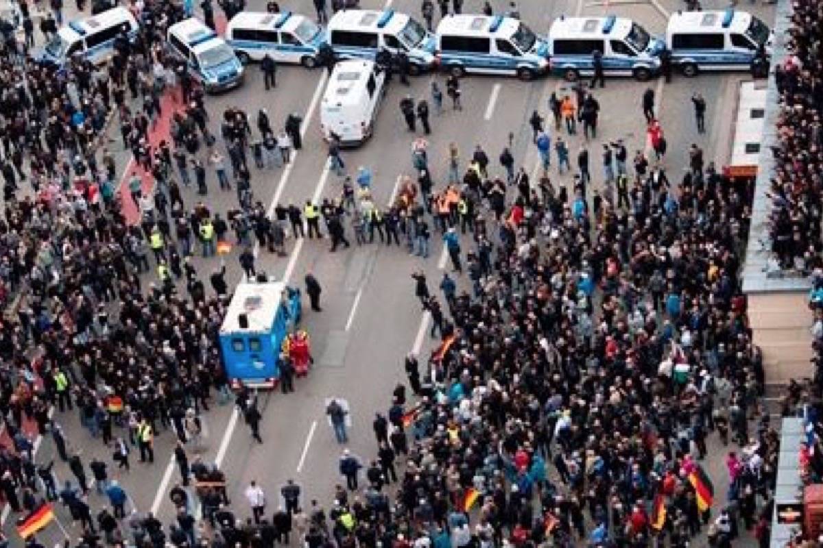 Police cars stand across the road as police separate leftist and nationalist demonstrators in Chemnitz, eastern Germany, Saturday, Sept. 1, 2018, after several nationalist groups called for marches protesting the killing of a German man last week, allegedly by migrants from Syria and Iraq. (dpa via AP)