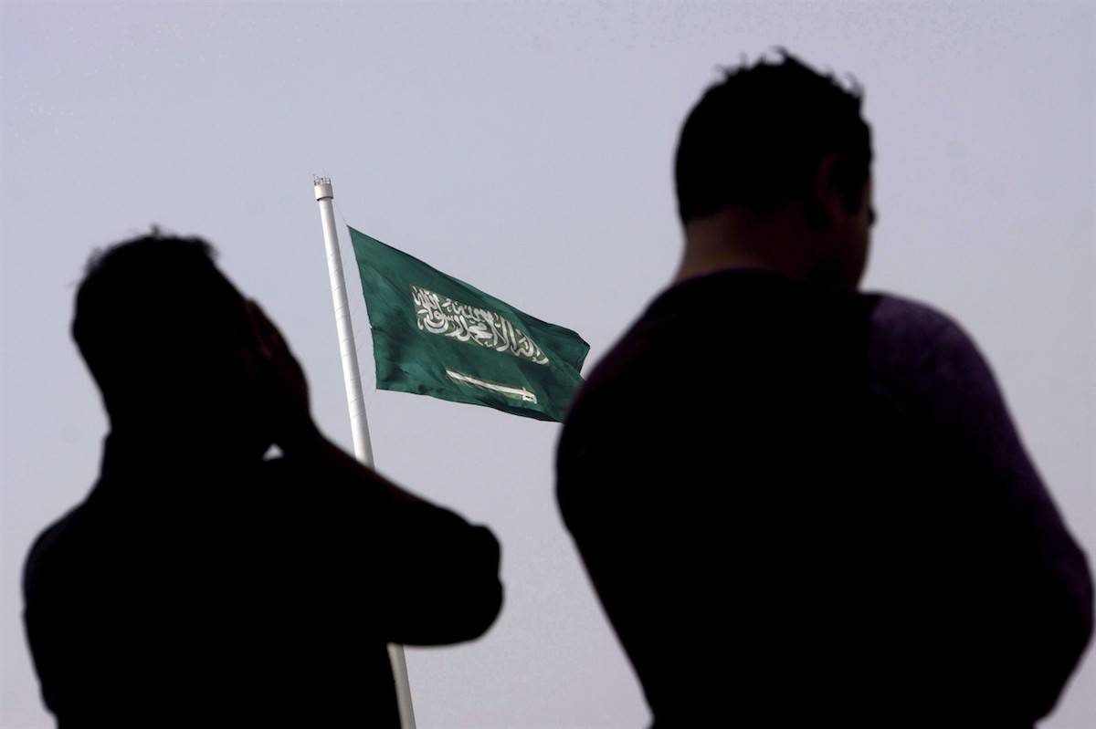 People pray at an open air makeshift mosque in front of a giant Saudi Flag in Jiddah, Saudi Arabia, Wednesday, June 21, 2017. THE CANADIAN PRESS/AP, Amr Nabil