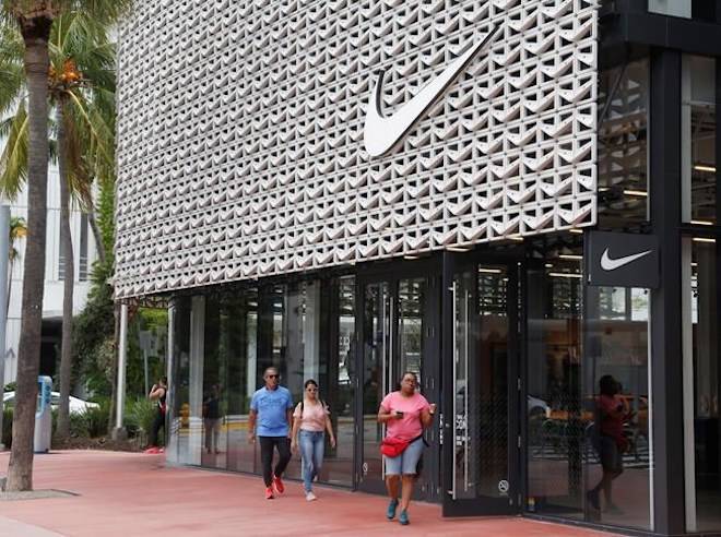 Shoppers walk past the Nike Miami store on the Lincoln Road Mall, Tuesday, Sept. 4, 2018, in Miami Beach, Fla. Nike’s stock was falling in early trading on Tuesday following an announcement that former San Francisco 49ers quarterback Colin Kaepernick has a new deal with the athletic clothing and footwear maker. (AP Photo/Wilfredo Lee)