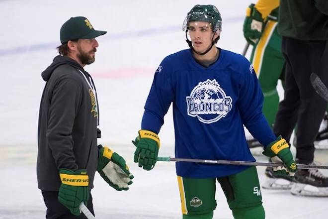 Humboldt Broncos returning player Brayden Camrud speaks with head coach Nathan Oystrick during a team practice Tuesday, Sept. 11, 2018. THE CANADIAN PRESS/Jonathan Hayward