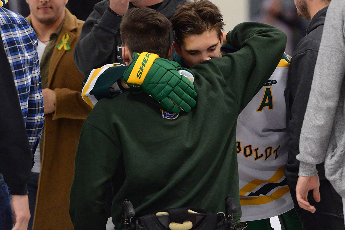 Returning Humboldt Broncos player Brayden Camrud (26) hugs former teammate Jacob Wassermann during a pregame ceremony before playing the Nipawin Hawks in the SJHL season home opener Wednesday, Sept. 12, 2018. The Humboldt Broncos were playing their first game since a bus crash claimed 16 lives in April. THE CANADIAN PRESS/Jonathan Hayward