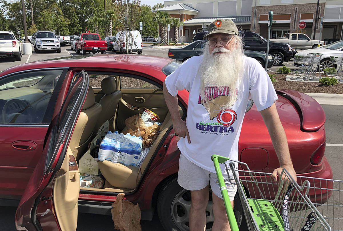 Steve Wareheim poses for a photo after making one last grocery run to prepare for Hurricane Florence at a grocery store in Ocean Isle Beach, N.C. on Wednesday, Sept. 12, 2018. Wareheim decided to ride out the storm at home after buying a generator this week. (AP Photo/Jeffrey Collins)