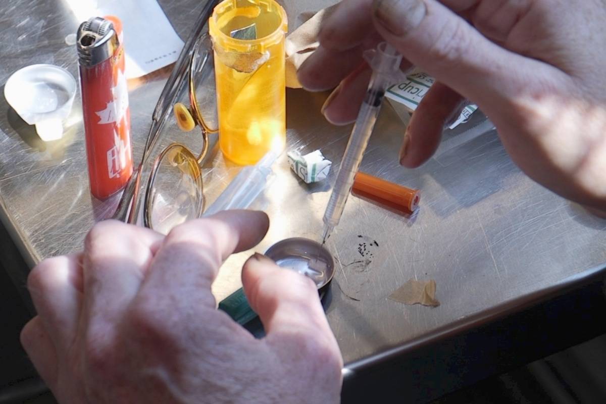 A drug user prepares drugs at theoverdose prevention site in Our Place in Victoria. (Arnold Lim/Black Press)