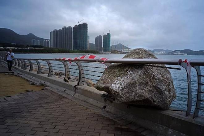 A big rock, which was blowed by Typhoon Mangkhut is stuck in between the fence on the waterfront of a house estate in Hong Kong, Monday, Sept. 17, 2018. (AP Photo/Vincent Yu)