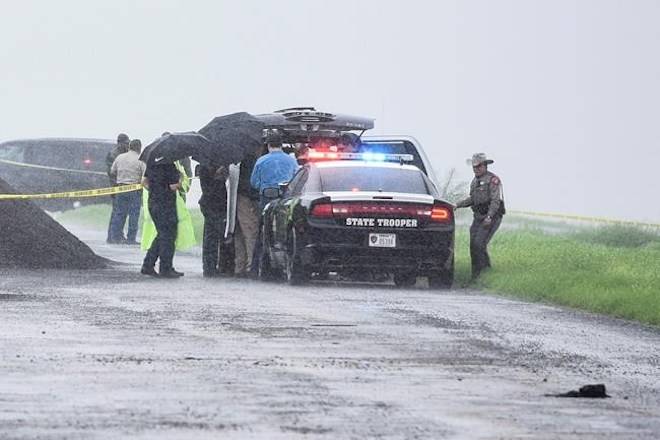Law enforcement officers gather near the scene where the body of a woman was found near Interstate 35 north of Laredo, Texas on Saturday, Sept. 15, 2018. (Danny Zaragoza/The Laredo Morning Times via AP)