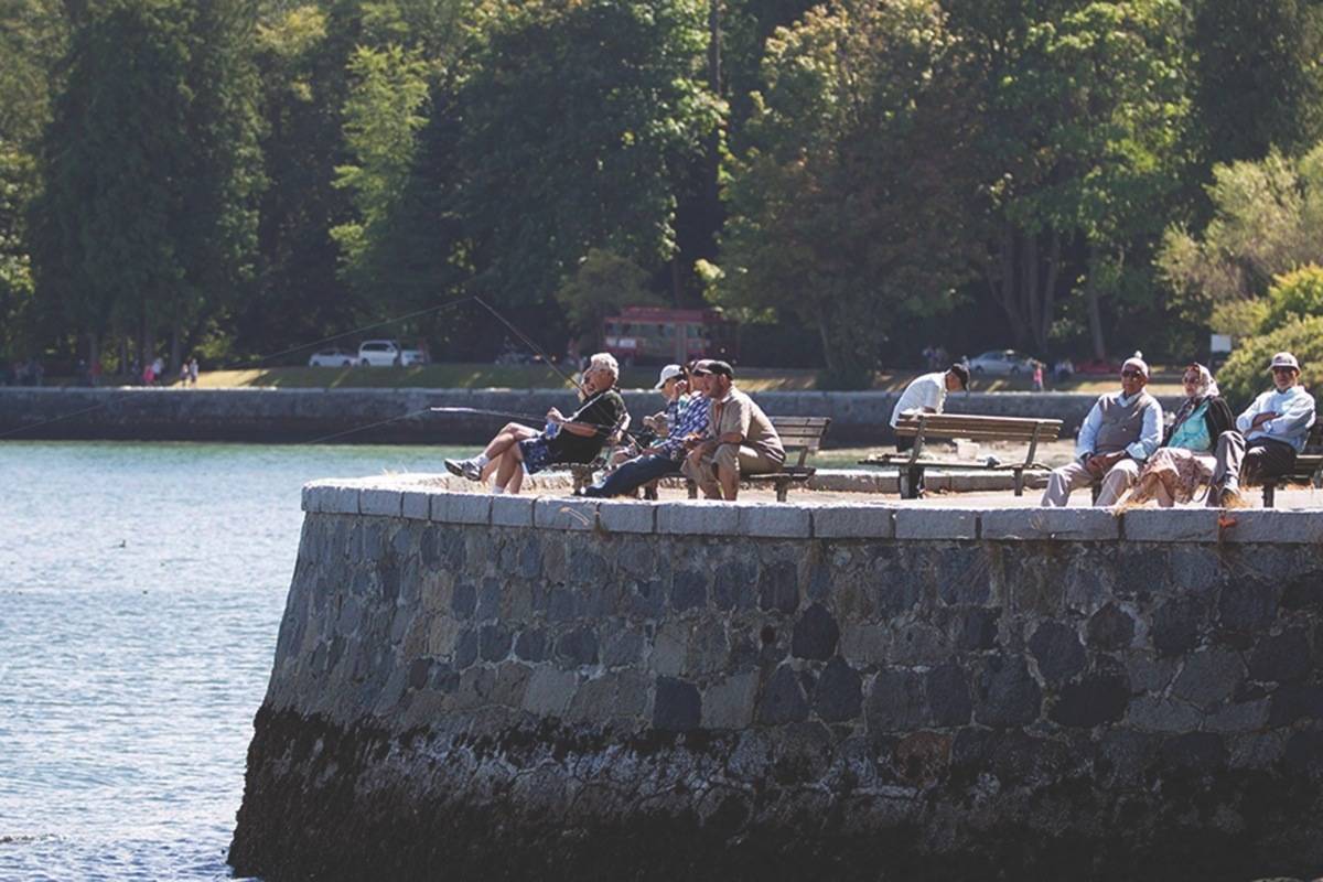 People sit along the Stanley Park seawall as others fish in Vancouver, B.C., on Sunday, August 25, 2013. THE CANADIAN PRESS/Darryl Dyck