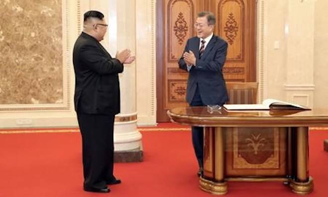 South Korean President Moon Jae-in, right, and North Korean leader Kim Jong Un react after signing a guest book before their summit at the headquarters of the Central Committee of the Workers’ Party in Pyongyang, North Korea, Tuesday, Sept. 18, 2018. (Pyongyang Press Corps Pool via AP)