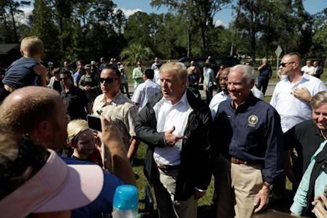 President Donald Trump visits a neighborhood impacted by Hurricane Florence, Wednesday, Sept. 19, 2018, in Conway, S.C., accompanied by South Carolina Gov. Henry McMaster and Sen. Lindsey Graham, R-S.C., right. (AP Photo/Evan Vucci)