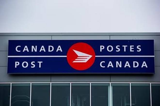 The Canada Post logo is seen on the outside the company’s Pacific Processing Centre, in Richmond, B.C., on Thursday June 1, 2017. An arbitrator has released a ruling in a long-standing pay equity dispute at Canada Post that gives rural carriers a hefty pay increase. THE CANADIAN PRESS/Darryl Dyck
