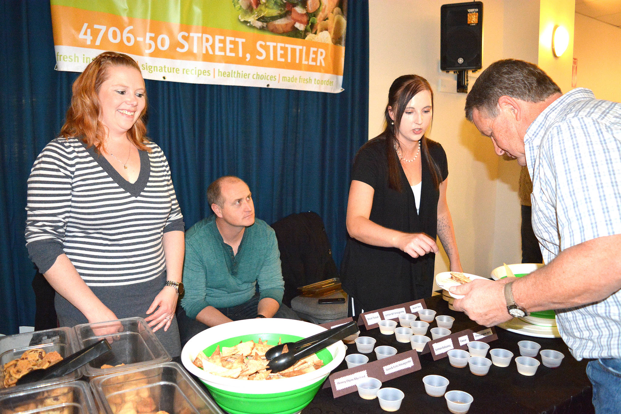 The Stettler Pita Pit served up appetizers at the Taste of Stettler event at the Hub on Sept. 21. From the Pita Pit are, from left, Amanda Ollerhead, Richard Ollerhead and Jaime Comchi. On the right Colin Brausen fills his plate with samples. Lisa Joy/Stettler Independent
