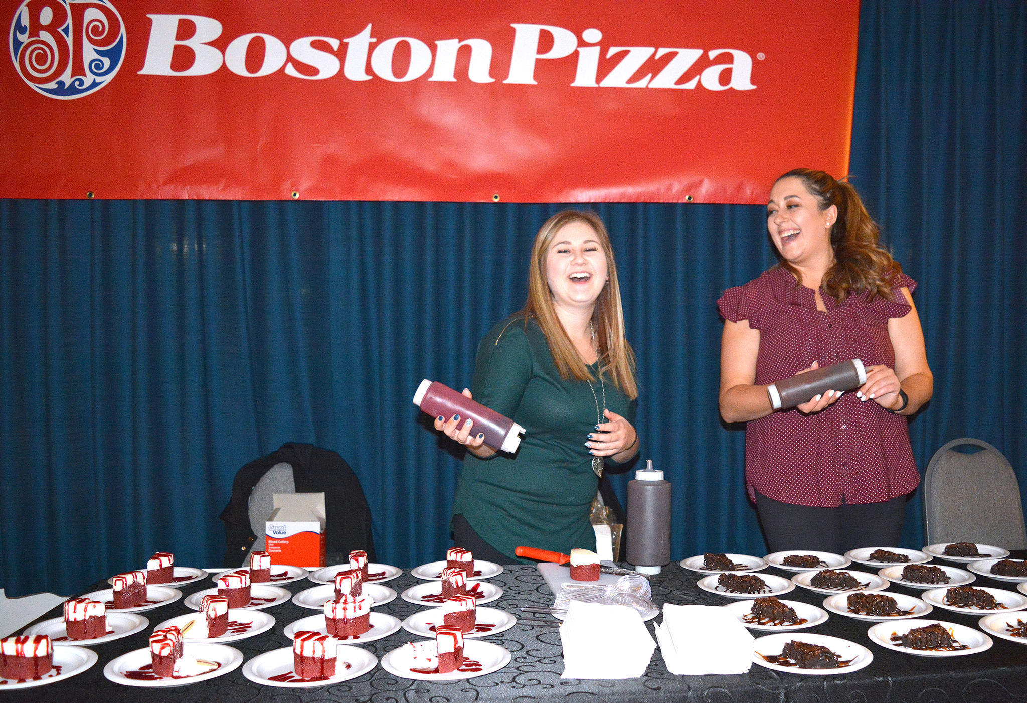Sarah Tschrieter and Paige Martin from Stettler Boston Pizza decorate delicious desserts during Taste of Stettler at the Hub on Sept. 21. Lisa Joy/Stettler Independent