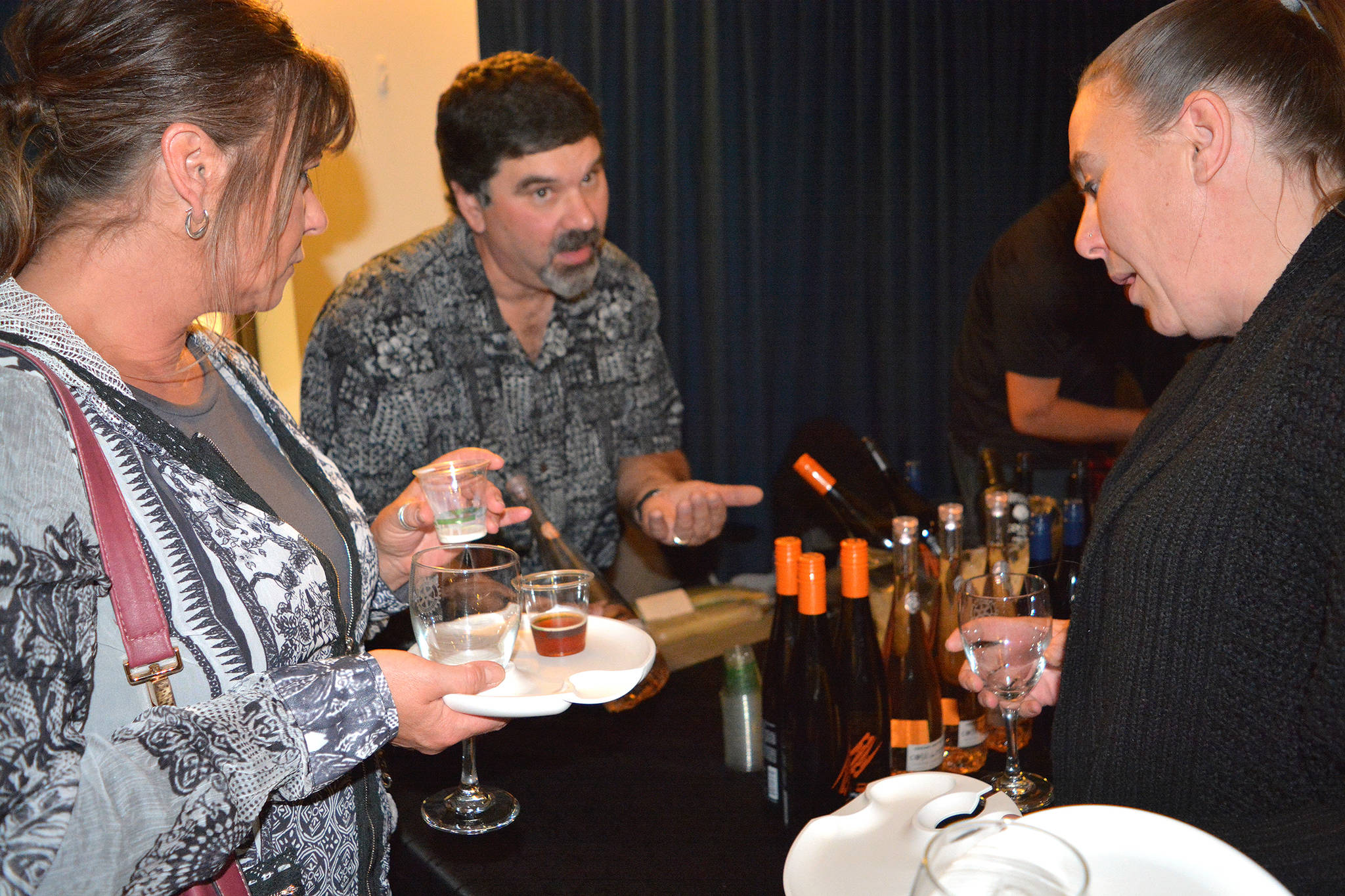 Rob Richmon of Stettler Co-op discusses various wines with Roxanne Dickie, left, and Brandi Page during Taste of Stettler Sept. 21. (Lisa Joy/Stettler Independent)