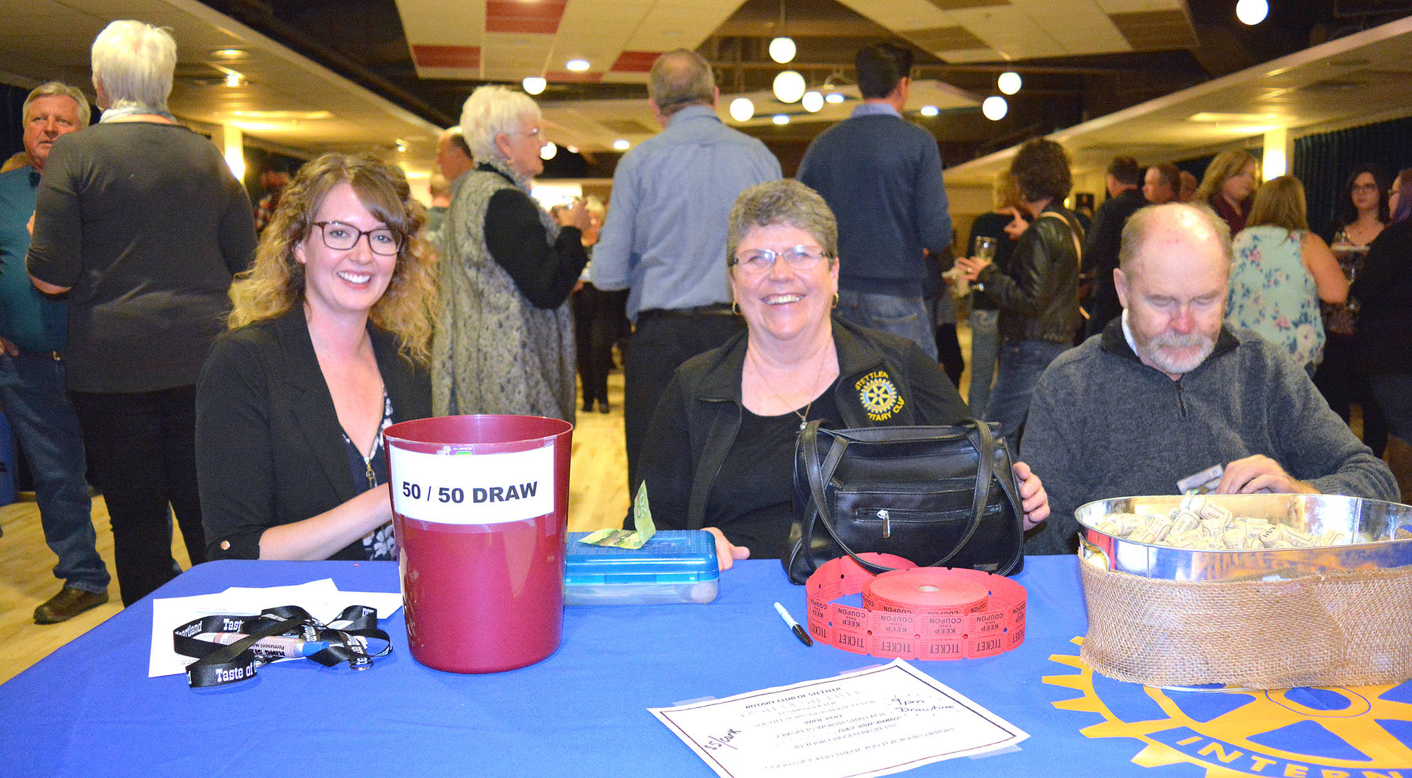 Stacey Benjamain from the Stettler Board of Trade, left, and Fran Snowden of Stettler Rotary Club sell tickets at Taste of Stettler, while Eric Snowden counts money. The 200 available tickets sold out fast for the annual Rotary Taste of Stettler event held at the Hub on Sept. 21. Lisa Joy/Stettler Independent
