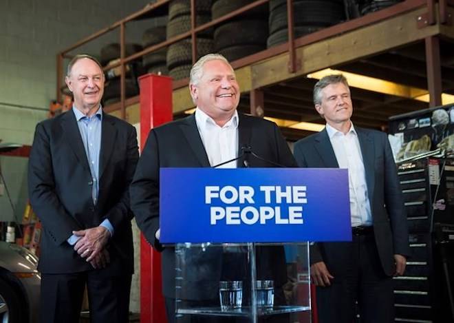 Premier Doug Ford, centre, speaks to the media with Rod Phillips, right, Minister of the Environment, Conservation and Parks, and John Yakabuski, Minister of Transportation regarding the decision to cancel the Ontario Drive Clean program in Toronto, on Sept. 28, 2018. NATHAN DENETTE/THE CANADIAN PRESS