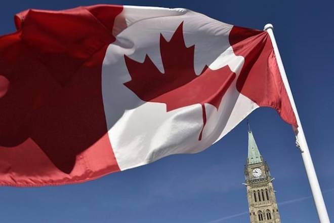 The Canadian flag is seen in front of the Peace Tower on Parliament Hill in Ottawa on October 2, 2017. THE CANADIAN PRESS/Justin Tang