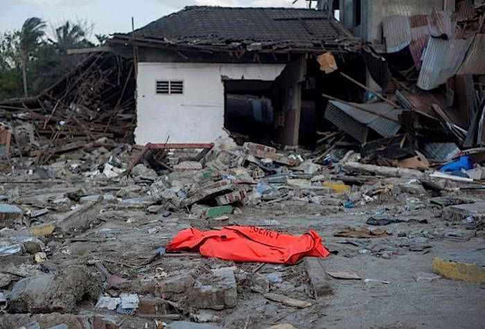 The body of a tsunami victim waits for evacuation at a village heavily damaged by Friday’s earthquake and tsunami in Palu, Central Sulawesi, Indonesia Indonesia, Wednesday, Oct. 3, 2018. (AP Photo/Fauzy Chaniago)