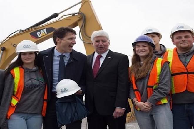 Prime Minister Justin Trudeau and Michigan Governor Rick Snyder pose with construction apprenticeship students in Windsor, Ont. Friday, Oct. 5, 2018. The federal government says the Gordie Howe Bridge, a multibillion-dollar construction project to build a link between Detroit and Windsor, is officially underway. THE CANADIAN PRESS/Troy Shantz
